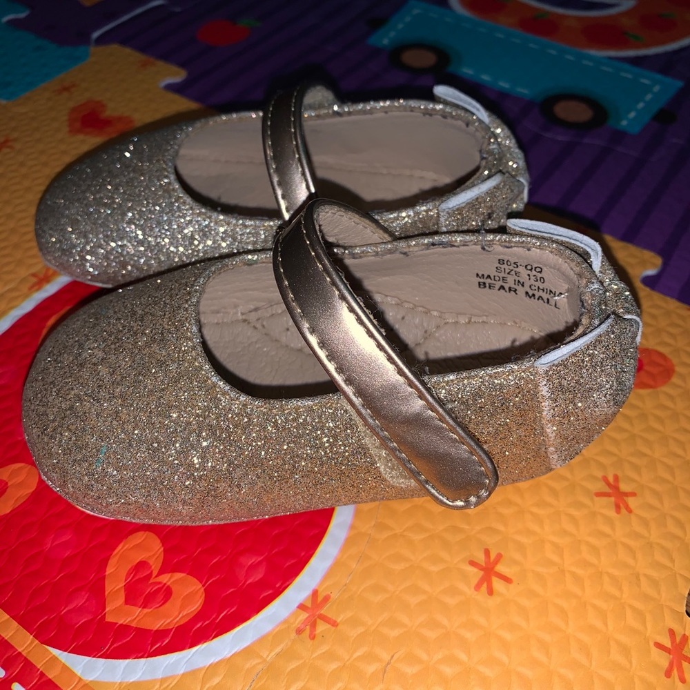 Sparkling gold dressy show with bow in the back.